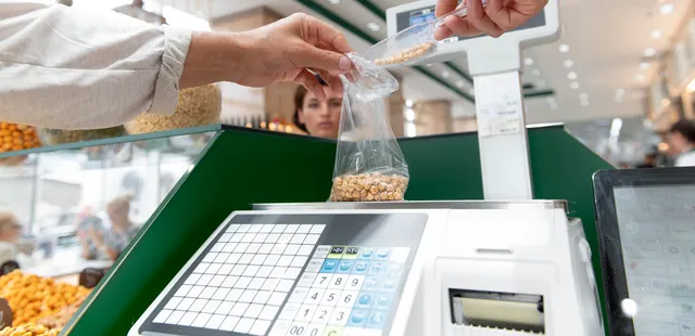 Balanza etiquetadora pesando producto a granel en supermercado