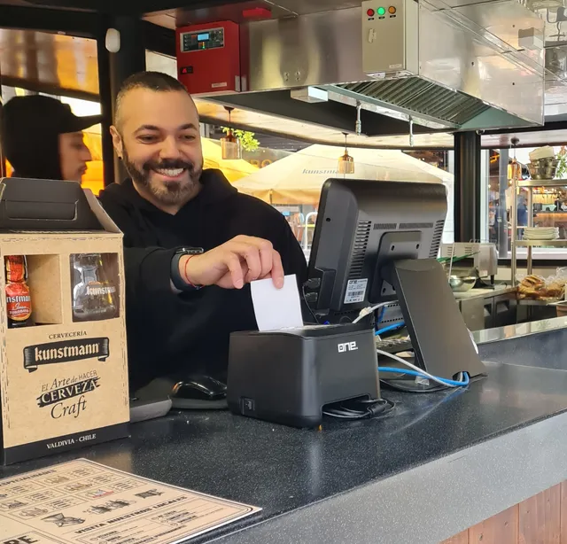 Cajero imprimiendo una boleta en el terminal POS de un restaurante